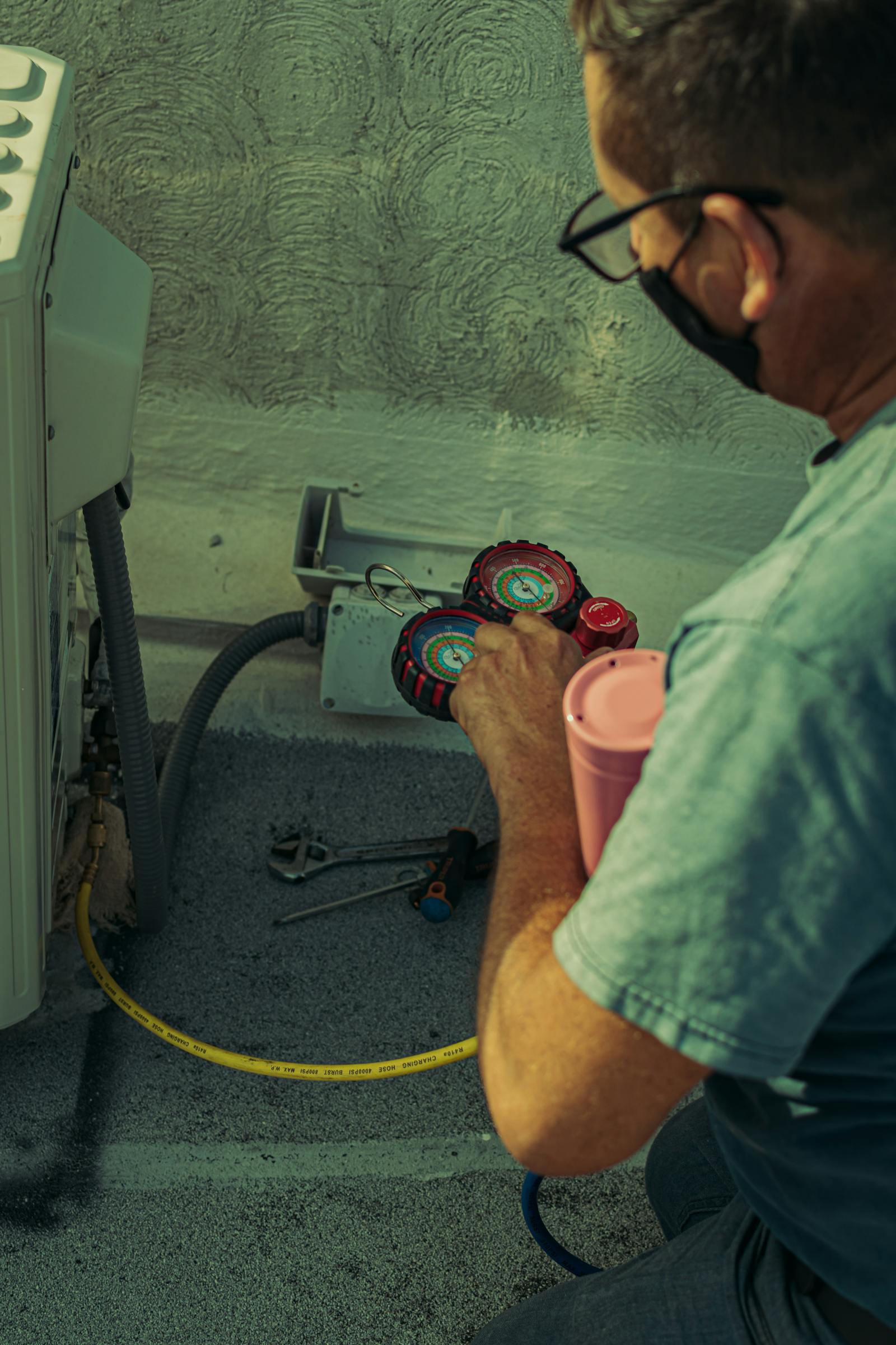 Air-conditioning technician checking a split system with manifold gauges